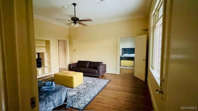 living room featuring crown molding, a ceiling fan, and wood finished floors