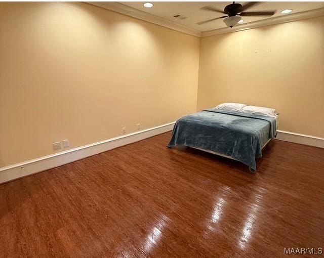 bedroom featuring recessed lighting, wood finished floors, baseboards, and ornamental molding