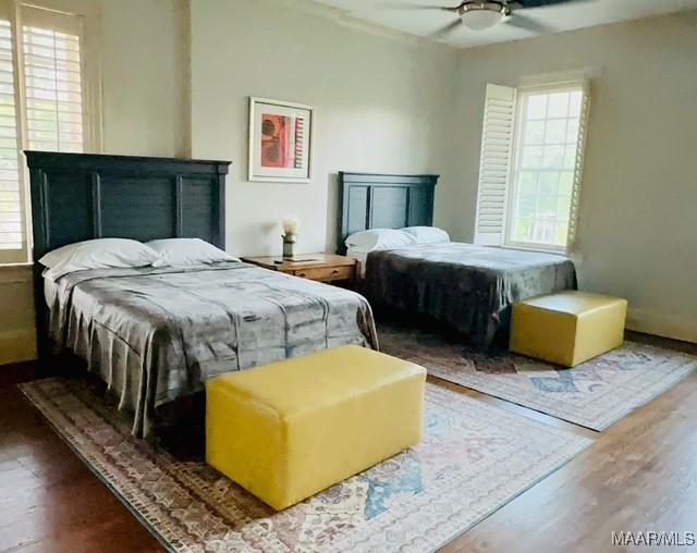 bedroom with wood finished floors, ceiling fan, and multiple windows
