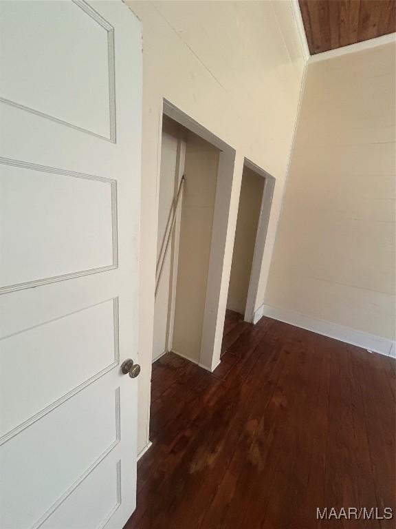 hallway featuring baseboards and hardwood / wood-style floors