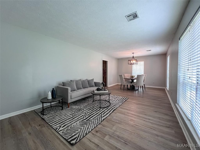 113 Kingston Pl, Prattville, AL 36067 - living room featuring baseboards, visible vents, wood finished floors, and a notable chandelier