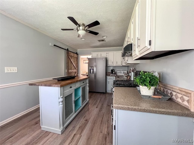 113 Kingston Pl, Prattville, AL 36067 - kitchen with a barn door, stainless steel fridge, wooden counters, white cabinets, and a ceiling fan