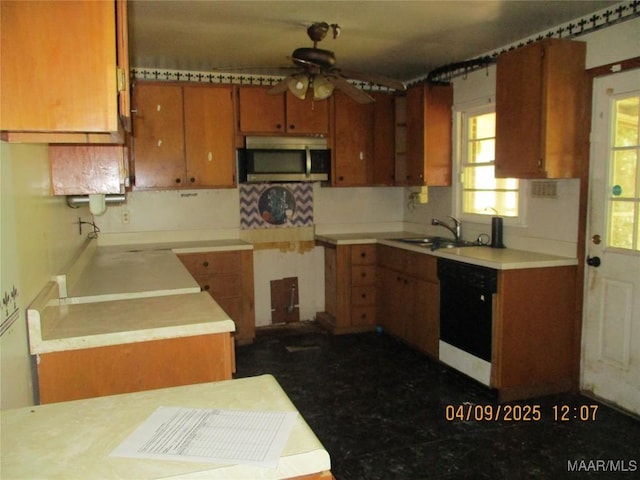kitchen with stainless steel microwave, a sink, ceiling fan, black dishwasher, and brown cabinetry