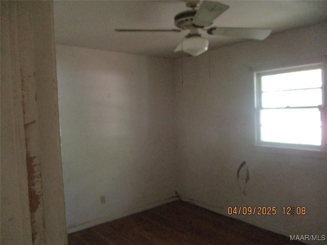 spare room with a ceiling fan and dark wood-type flooring