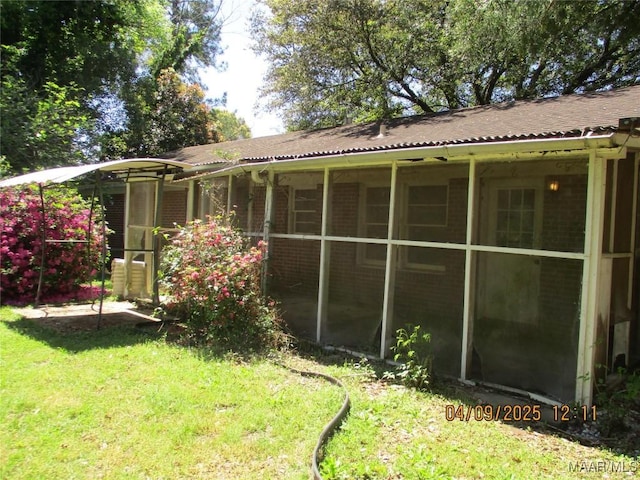 exterior space featuring a yard and a sunroom