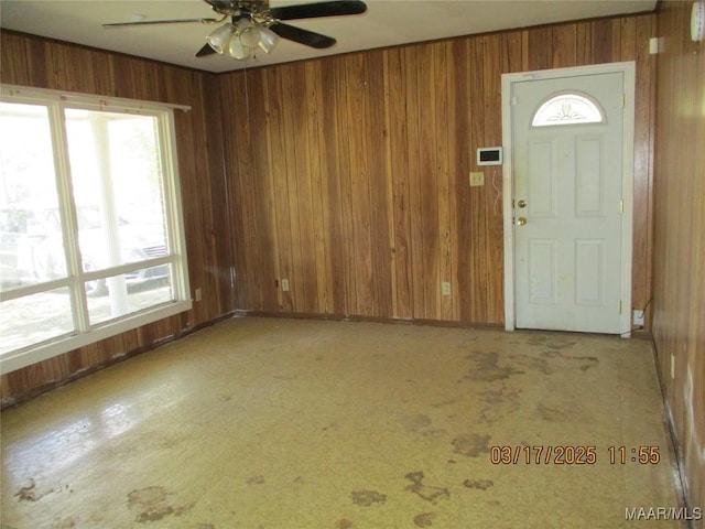 entrance foyer with wooden walls and ceiling fan