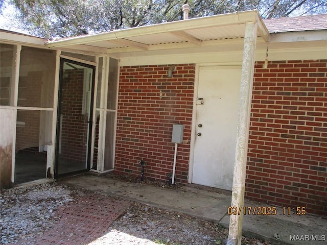 entrance to property featuring brick siding