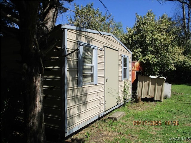 view of side of home featuring an outbuilding and a lawn