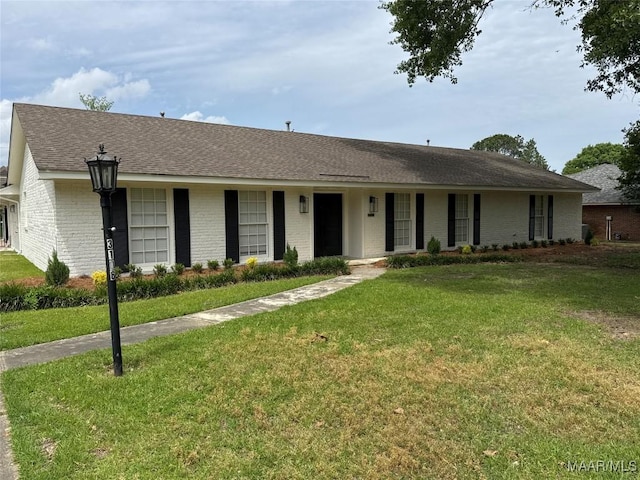 ranch-style house featuring roof with shingles, a front lawn, and brick siding