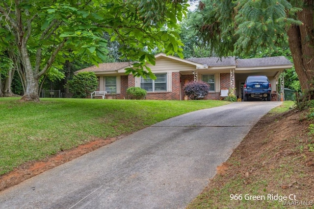single story home featuring concrete driveway, a front yard, an attached carport, and brick siding
