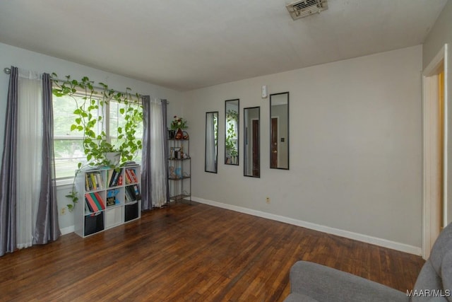 living area with visible vents, wood finished floors, and baseboards
