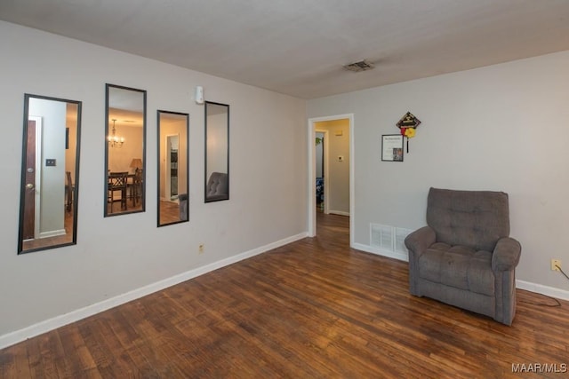 unfurnished room with baseboards, visible vents, wood finished floors, and an inviting chandelier