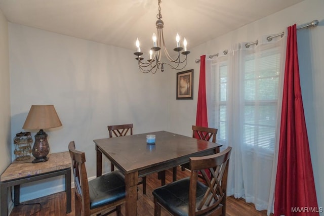 dining space featuring wood finished floors and a notable chandelier