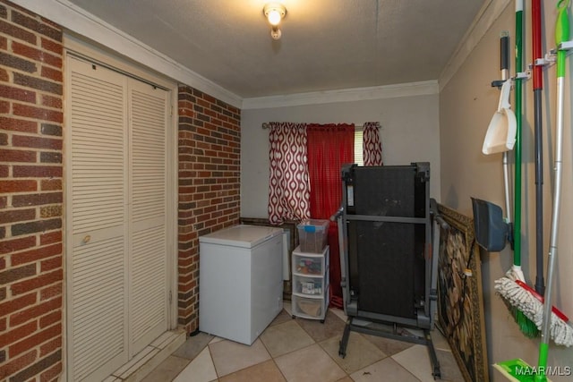 clothes washing area featuring light tile patterned floors and ornamental molding