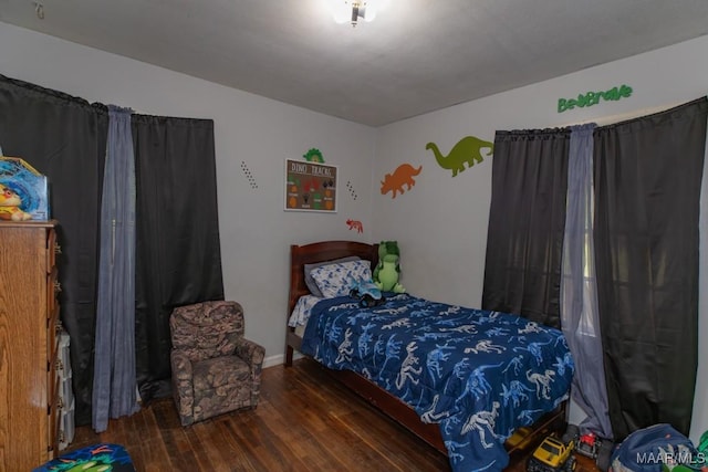 bedroom with wood finished floors and baseboards
