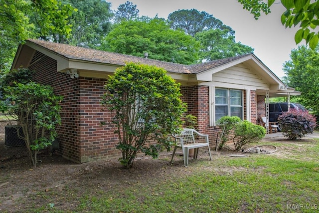 back of house featuring a lawn and brick siding