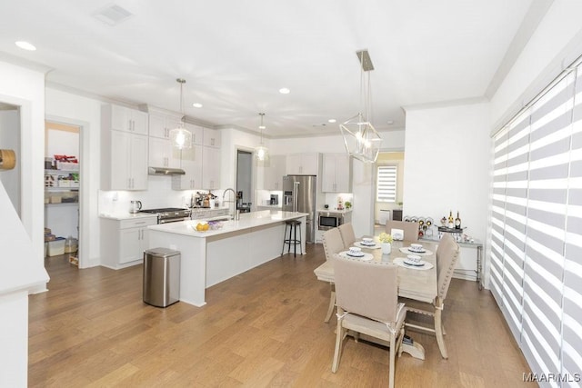 dining room with light wood-style floors, recessed lighting, and visible vents