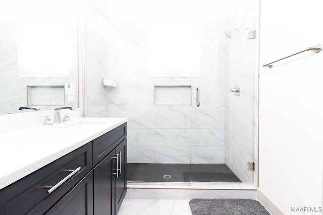 bathroom featuring marble finish floor, a shower stall, and vanity