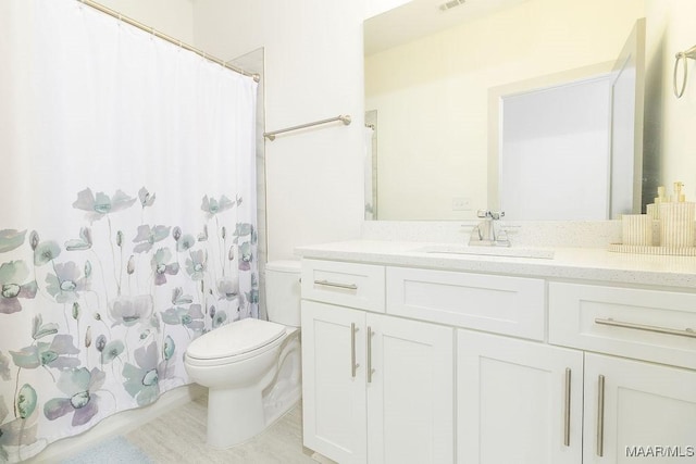 bathroom featuring visible vents, a shower with shower curtain, toilet, and vanity