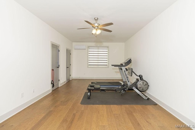 workout area with baseboards, wood finished floors, ceiling fan, and a wall mounted AC