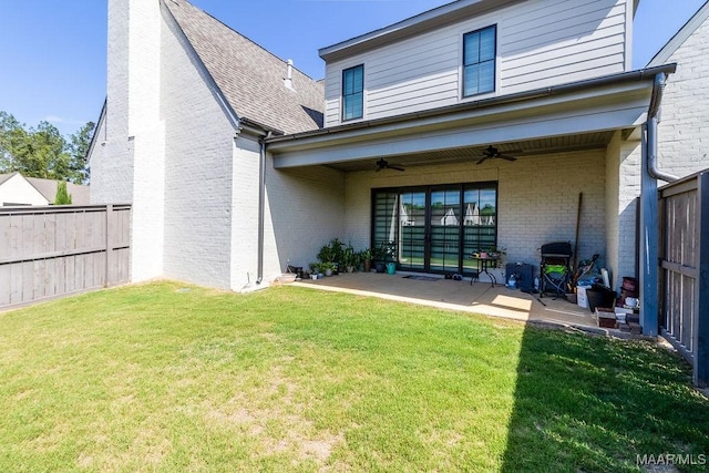 rear view of house with ceiling fan, a patio, brick siding, and a fenced backyard