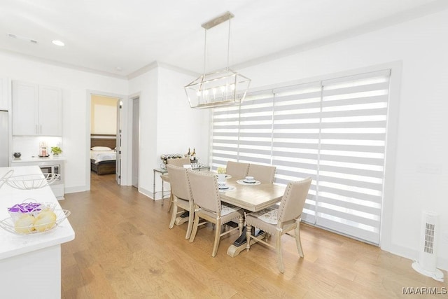 dining space with light wood finished floors and a notable chandelier