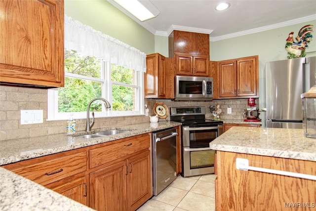 kitchen with tasteful backsplash, light stone countertops, stainless steel appliances, and a sink