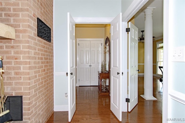 hall featuring wood finished floors, visible vents, and brick wall