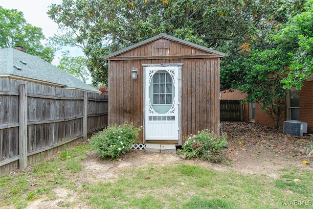 view of shed with cooling unit and a fenced backyard