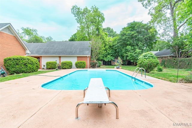 view of swimming pool with a patio, a diving board, a fenced in pool, and a lawn