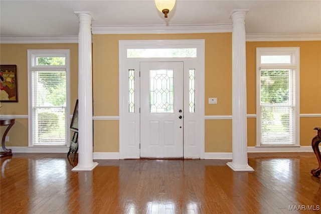 entrance foyer featuring ornate columns, crown molding, and baseboards