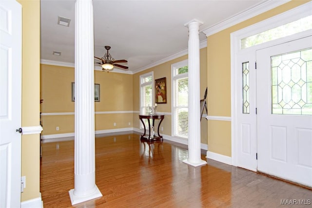 entryway with ceiling fan, visible vents, ornate columns, ornamental molding, and wood finished floors