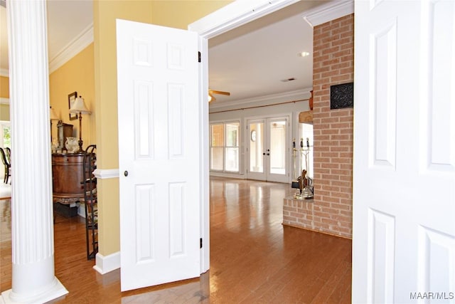 corridor featuring wood finished floors, crown molding, and plenty of natural light