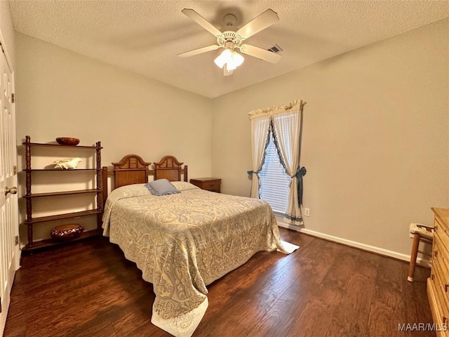 bedroom featuring a textured ceiling, visible vents, baseboards, and dark wood-type flooring