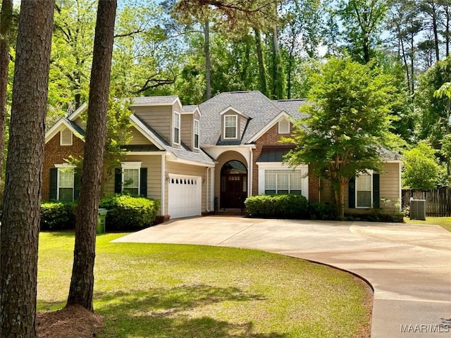 view of front of home with a front lawn, a garage, cooling unit, driveway, and fence