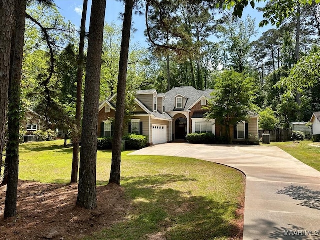 traditional-style home featuring fence, driveway, an attached garage, and a front yard