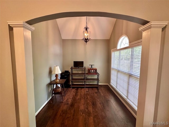 interior space featuring lofted ceiling, a chandelier, baseboards, arched walkways, and wood finished floors