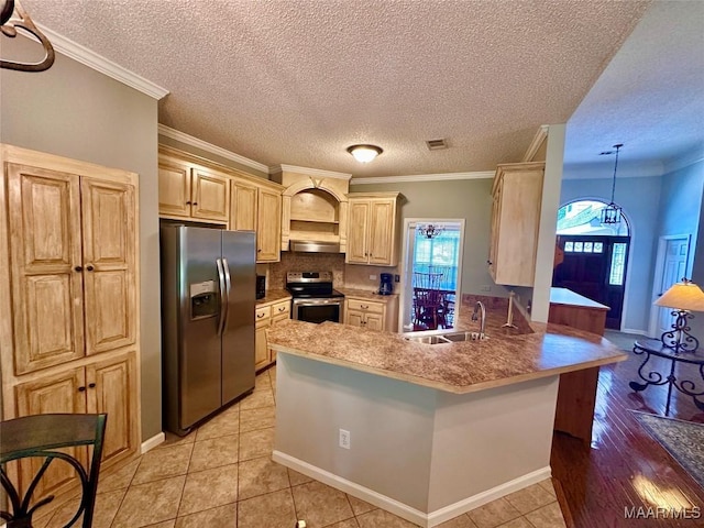 kitchen with a sink, visible vents, a peninsula, ornamental molding, and appliances with stainless steel finishes