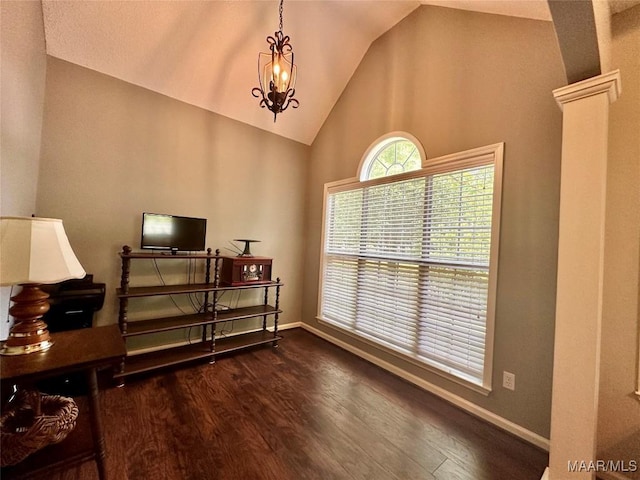 interior space with ornate columns, dark wood-style flooring, high vaulted ceiling, and baseboards