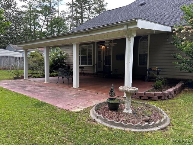 back of property featuring a lawn, a patio, and a shingled roof