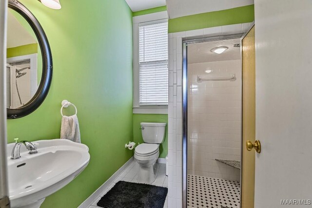 48 S Capitol Pkwy, Montgomery, AL 36107 - bathroom featuring tile patterned floors, a shower stall, toilet, a sink, and baseboards