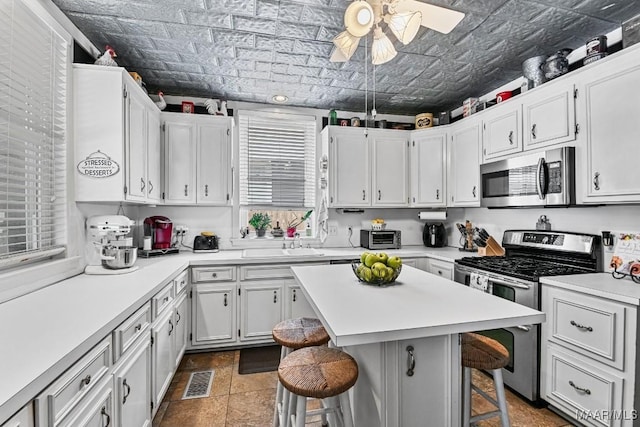 48 S Capitol Pkwy, Montgomery, AL 36107 - kitchen featuring a kitchen breakfast bar, appliances with stainless steel finishes, visible vents, an ornate ceiling, and a ceiling fan