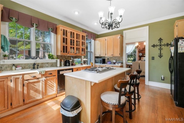 100 S Franklin Ave, Luverne, AL 36049 - kitchen featuring a center island, tasteful backsplash, light countertops, black appliances, and a chandelier