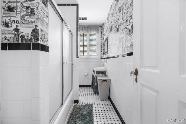 100 S Franklin Ave, Luverne, AL 36049 - bathroom with visible vents, tile walls, a shower with shower door, a sink, and tile patterned floors