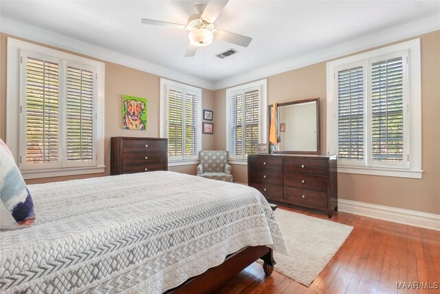 100 S Franklin Ave, Luverne, AL 36049 - bedroom featuring wood-type flooring, crown molding, visible vents, baseboards, and a ceiling fan