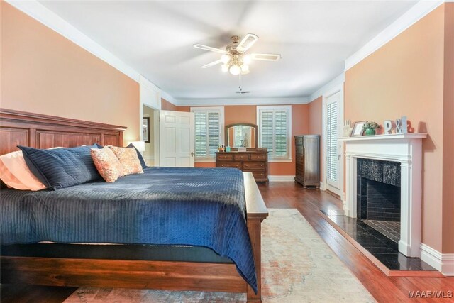100 S Franklin Ave, Luverne, AL 36049 - bedroom with baseboards, ceiling fan, wood finished floors, and a fireplace
