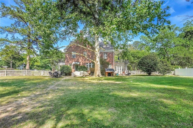 100 S Franklin Ave, Luverne, AL 36049 - back of house featuring a yard, brick siding, and a fenced backyard