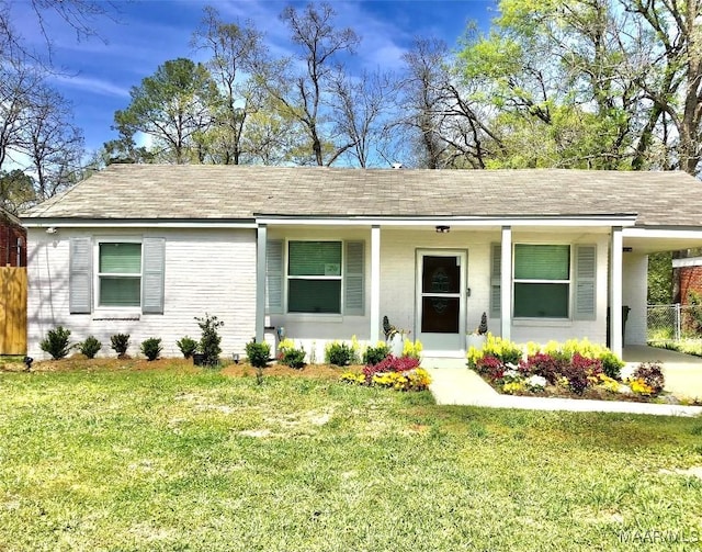 single story home with a front yard, a carport, fence, and roof with shingles