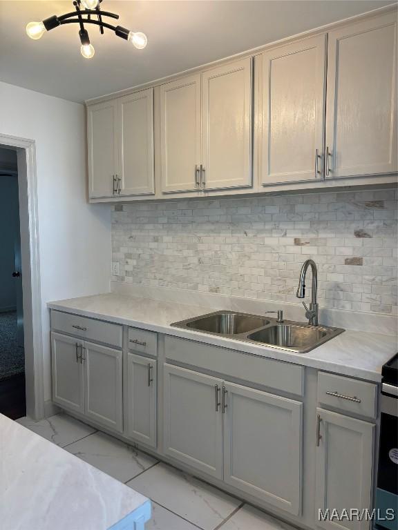 644 Iris Ln, Montgomery, AL 36105 - kitchen featuring light marble finish floors, gray cabinetry, and a sink