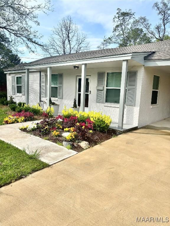 644 Iris Ln, Montgomery, AL 36105 - view of front of house with brick siding, a porch, concrete driveway, and a shingled roof